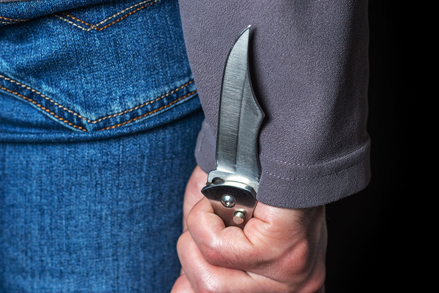 Teenager holds knife behind back